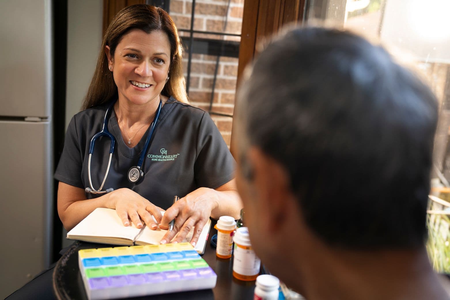 A Commonheart Home Health Nurse helping a patient with his medication